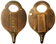 “U.S.EX.Co.”. Brass body. Brass shackle. There is a hole going through the case