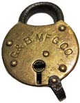 “G.&B. MFG. CO.”. 2 3/8″ high x 1 3/4″ wide. Stamped Brass body. Steel shackle.