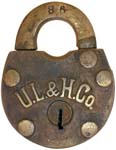 “U. L. & H. Co.”. 2 5/8″ high x 2″ wide x 5/8″ deep. Brass body. Brass shackle.