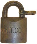“N. T. CO”. 1 1/2″ wide. Brass body. Brass shackle.