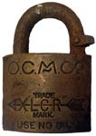 “O.C.M.CO” – “XLCR TRADE MARK” – “USE NO OIL”. 2″ wide. Brass body. Steel shackl