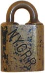 “N.Y.C.R.R.”. 1 1/8″ wide. Brass body. Brass shackle. The reverse of the case is