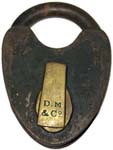 “D. M & Co”. 3 1/4″ high x 2 3/8″ wide. Iron body. Iron shackle. The reverse of
