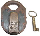 “D. M & Co”. 3 1/2″ high x 2 1/2″ wide. Iron body. Iron shackle. The reverse of