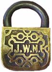“J. W. M.”. 2″ high. Brass body. Steel shackle. The reverse of the case is the s